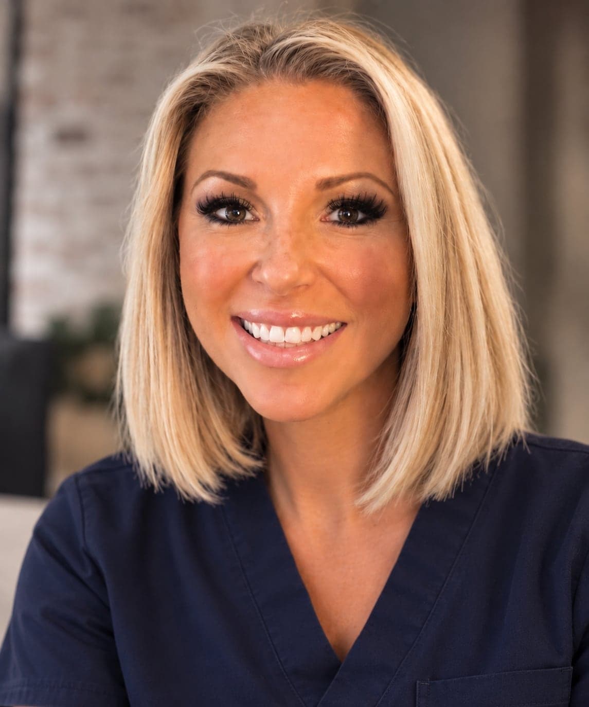 Danielle Davies, smiling, in navy nurse's scrubs